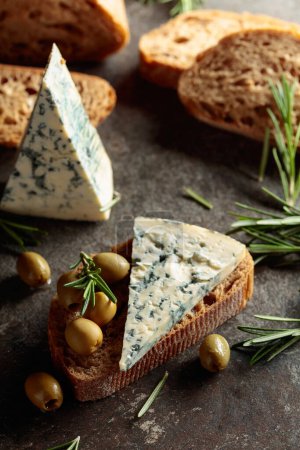 Photo for Blue cheese with green olives, rosemary, and fresh bread. - Royalty Free Image