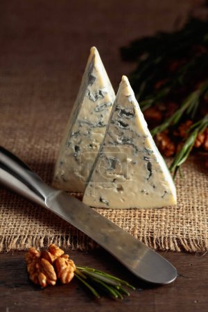 Photo for Blue cheese with walnuts and rosemary on an old wooden table. - Royalty Free Image