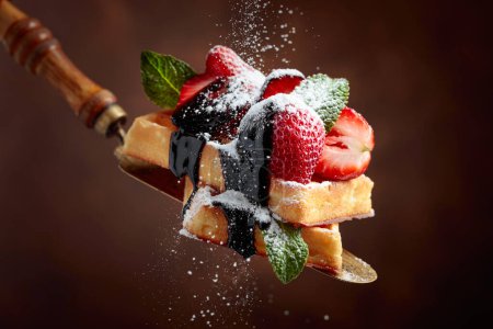 Téléchargez les photos : Gaufres belges aux fraises, menthe et sauce au chocolat, saupoudrées de sucre en poudre. - en image libre de droit