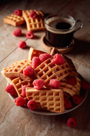 Photo for Belgian waffles with raspberries and black coffee on a brown background. - Royalty Free Image