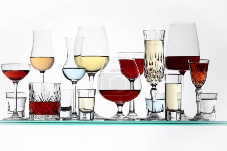 Téléchargez les photos : Various alcoholic drinks in the bar on glass shelves. - en image libre de droit