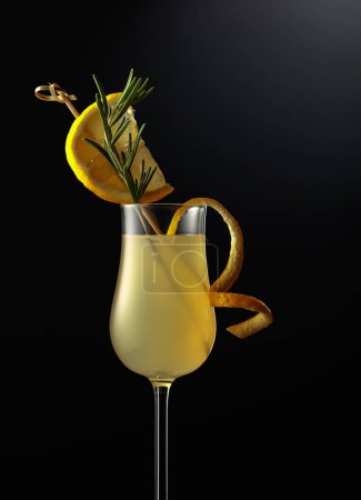 Téléchargez les photos : Limoncello en verre, liqueur de citron italienne sucrée, boisson alcoolisée forte traditionnelle garnie de tranches de citron et de romarin. - en image libre de droit