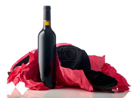 Foto de Botella de vino tinto con papel crepé rojo y negro arrugado aislado sobre fondo blanco. - Imagen libre de derechos