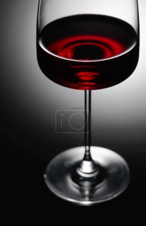 Photo for The glass of red wine. Black background, backlight. - Royalty Free Image