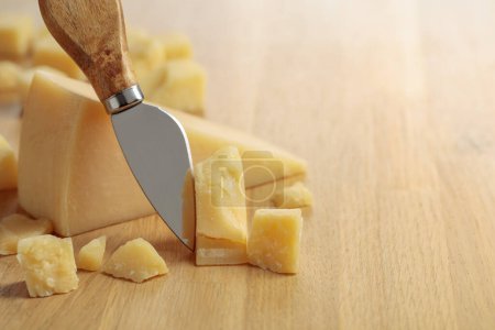 Photo for Parmesan cheese and knife on a wooden cutting board. - Royalty Free Image