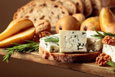 Photo for Sandwich with blue cheese and pears. On an old wooden table bread, blue cheese, pears, walnuts, and rosemary. - Royalty Free Image