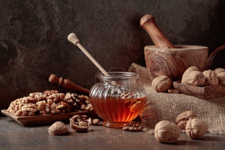 Photo for Honey and walnuts on an old kitchen table. - Royalty Free Image