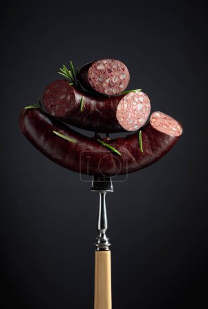 Photo for Black pudding or blood sausage with rosemary on a fork. - Royalty Free Image