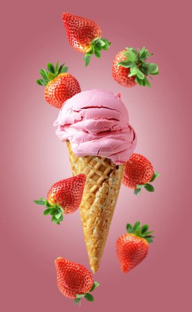 Photo for Strawberry ice cream in a waffle cone with falling fresh berries on a pink background. - Royalty Free Image