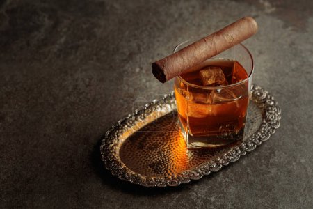 Foto de Whiskey with ice and cigar on a silver tray. Copy space. - Imagen libre de derechos