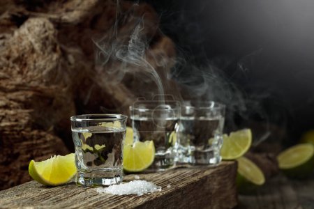 Photo for Tequila with salt and lime slices on an old wooden board. - Royalty Free Image
