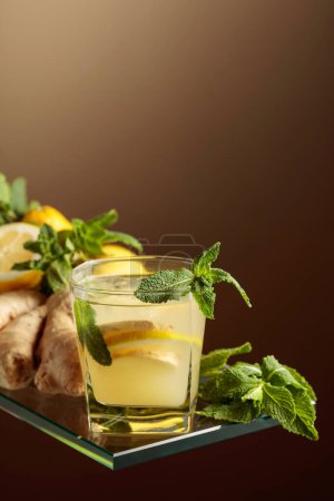Photo for Ginger ale beer cocktail with lemon and mint in a frozen glass. Refreshing summer cocktail with natural ice, ginger, lemon, and mint. Copy space. - Royalty Free Image