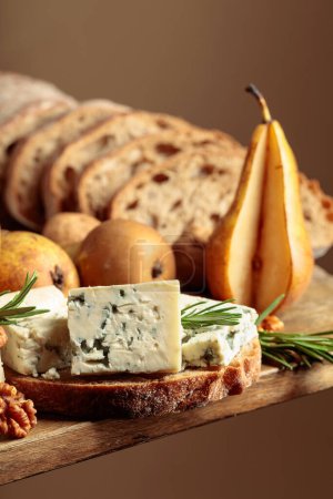 Téléchargez les photos : Sandwich au fromage bleu et aux poires. Sur une vieille table en bois pain, fromage bleu, poires, noix et romarin. - en image libre de droit