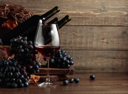 Photo for Red wine and blue grapes. Wine and grapes in a vintage setting on an old wooden table. - Royalty Free Image