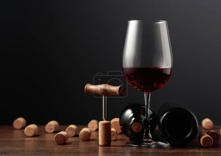 Photo for Red wine and wine corks on a wooden table. Copy space. - Royalty Free Image