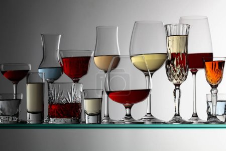 Foto de Varias bebidas alcohólicas en un bar en un estante de vidrio. - Imagen libre de derechos