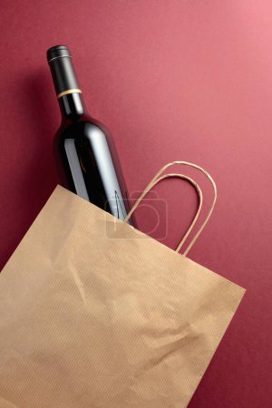 Téléchargez les photos : Sac à provisions en papier recyclé avec une bouteille de vin rouge. Vue du dessus, espace de copie. - en image libre de droit