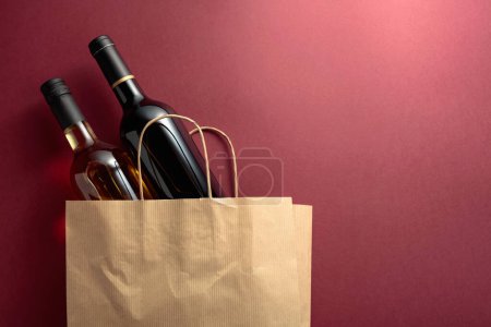 Foto de Bolsa de compras de papel reciclado con botellas de vino tinto y blanco. Vista superior, espacio de copia. - Imagen libre de derechos