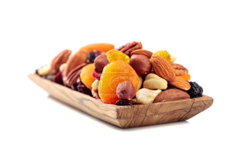 Téléchargez les photos : Mélange de noix et de fruits secs isolés sur un fond blanc. Abricots, raisins secs, noix, noisettes, noix de cajou, pacanes et amandes présentés. - en image libre de droit