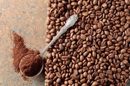 Photo for Ground coffee in a spoon and coffee beans on a rusty metal background. Top view. Copy space. - Royalty Free Image