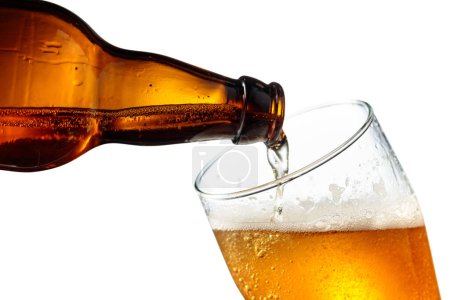 Téléchargez les photos : Verser la bière d'une bouteille dans un verre. Isolé sur fond blanc. - en image libre de droit