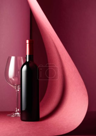 Photo for Bottle of red wine and an empty glass on a red background. Copy space. - Royalty Free Image