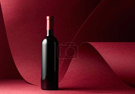 Photo for Bottle of red wine on a red background. Copy space. - Royalty Free Image