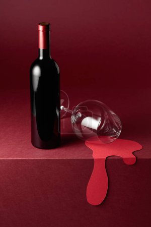 Téléchargez les photos : Bouteille et verre de vin rouge sur fond rouge. Concept du thème du vin rouge. Espace de copie. - en image libre de droit