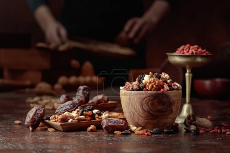 Foto de Varios frutos secos y frutos secos están en un tazón de madera en una mesa de cocina. Enfoque selectivo. - Imagen libre de derechos