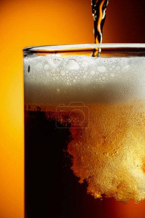 Téléchargez les photos : Verre de bière savoureuse avec mousse, gros plan. Verser la bière avec mousse à bulles en verre pour le fond et le design. - en image libre de droit