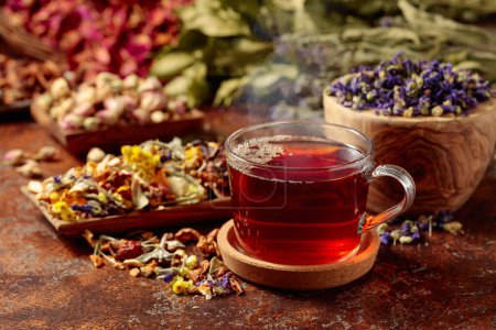 Photo for Herbal tea and a mix of various dried medicinal plants and herbs on a brown vintage background. - Royalty Free Image