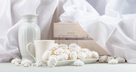 Photo for Small white meringues in a white dish on the white table. - Royalty Free Image