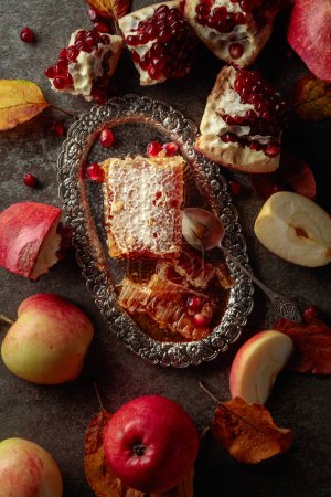 Téléchargez les photos : Apple, pomegranate, and honey, are the traditional food for Jewish New Year - Rosh Hashana. Honeycomb and fruits on an old stone table. - en image libre de droit