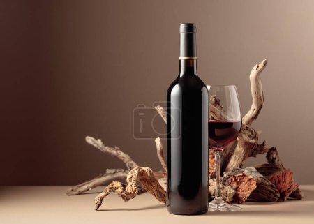 Foto de Botella y copa de vino tinto con una composición de madera vieja. Composición minimalista sobre un fondo beige para la marca del producto, la identidad y el embalaje. Copiar espacio. - Imagen libre de derechos