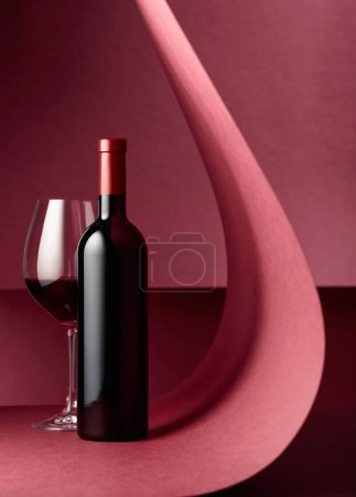 Foto de Botella y copa de vino tinto sobre fondo rojo. Copiar espacio
. - Imagen libre de derechos