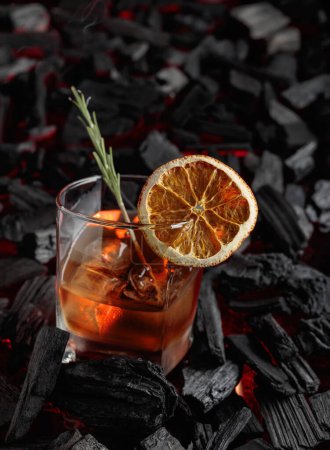 Téléchargez les photos : Cocktail à l'ancienne avec whisky, glace, tranches d'orange séchées et romarin. - en image libre de droit