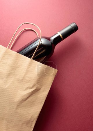 Einkaufstasche aus recyceltem Papier mit einer Flasche Rotwein. Ansicht von oben, Kopierraum.