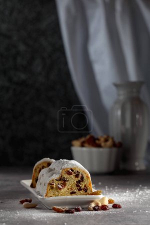 Photo for Traditional fruit cake with raisins and nuts sprinkled with sugar powder. - Royalty Free Image