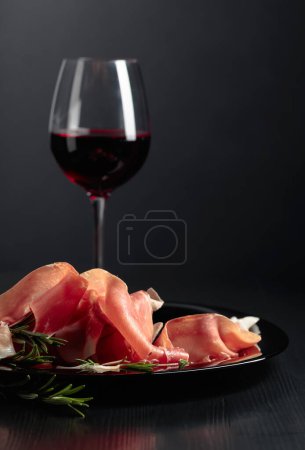 Photo for Italian prosciutto or Spanish jamon with rosemary and red wine. Copy space. - Royalty Free Image