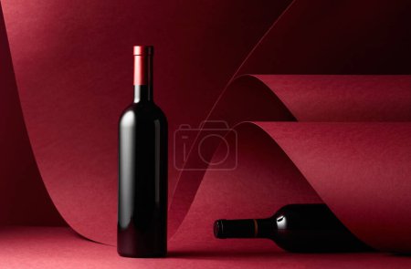Photo for Bottles of red wine on a red background. Copy space. - Royalty Free Image
