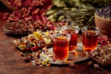Photo for Herbal tea and a mix of various dried medicinal plants and herbs on a brown vintage background. - Royalty Free Image
