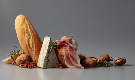 Téléchargez les photos : Prosciutto au fromage bleu, baguette, noix et thym. Snacks méditerranéens traditionnels. - en image libre de droit