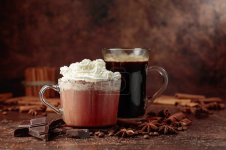 Photo for Hot chocolate with whipped cream and black coffee. Hot holiday drinks with ingredients on a brown table. - Royalty Free Image