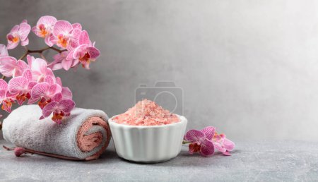 Piękne kwitnące kwiaty storczyka i różowa sól morska. Obraz koncepcyjny spa z przestrzenią do kopiowania.