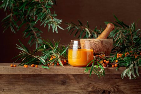 Photo for Glass of sea buckthorn juice with fresh berries on an old wooden table. Copy space. - Royalty Free Image