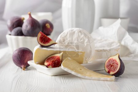 Photo for Camembert cheese with figs on a white wooden table. - Royalty Free Image