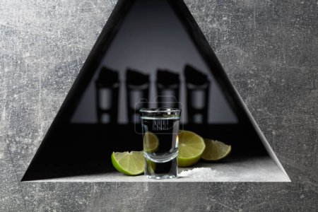 Téléchargez les photos : Tequila with lime slices and sea salt on a grey stone background. - en image libre de droit