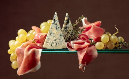 Foto de Uvas con queso azul, jamón y tomillo. Snacks mediterráneos. Copiar espacio. - Imagen libre de derechos