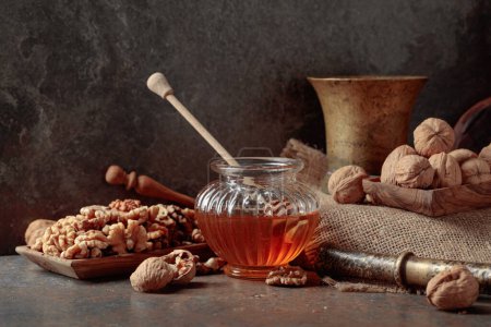 Photo for Honey and walnuts on an old kitchen table. - Royalty Free Image