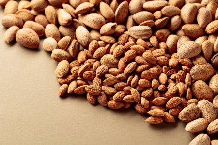 Photo for Almonds on a brown background. Top view with copy space. - Royalty Free Image